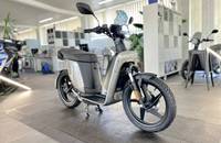 E-Scooter in Anthrazitgrau in einem hellen Showroom.