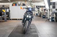 Frontalansicht eines schwarzen Motorrads in einem Showroom.