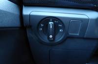 Nahaufnahme eines Bedienelements im Fahrzeuginnenraum mit Drehregler und Knöpfen.