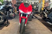 Frontansicht eines roten E-Motorrads (ZERO) in einem Showroom.
