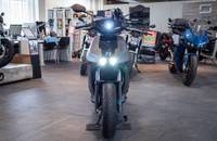 Frontansicht eines grauen E-Motorrads, das in einem Showroom ausgestellt ist.