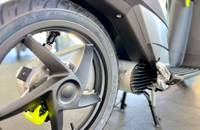 Nahaufnahme des Vorderrades, des Reifens und des Motorbereichs eines E-Scooters.