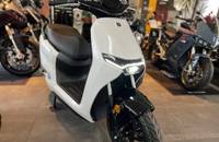 Frontansicht eines weißen E-Scooters mit modernen Scheinwerfern und Reifen.