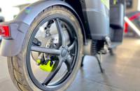 Nahaufnahme des Hinterrads eines E-Scooters. Zu sehen sind der Reifen, die Felge und der gelbe Bremssattel.