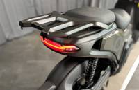 Heckansicht eines grauen E-Scooters mit Heckgepäckträger und Beleuchtung.