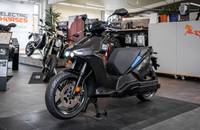 Seitenansicht eines schwarzen E-Scooters in einem Autohaus.
