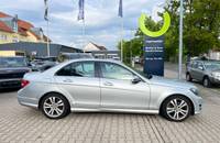 Seitenansicht eines silbernen Mercedes-Benz C-Klasse vor dem Autohaus Richter & Zech.