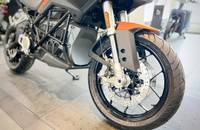 Seitenansicht eines orangefarbenen E-Motorrads mit großen Felgen und modernem Design.