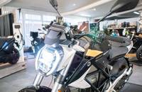 Frontansicht eines schwarzen Elektro-Motorrads mit hellem Scheinwerfer.