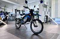 Außenansicht eines blauen E-Motorrads in einem Showroom.