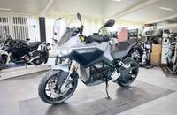 Ein silbernes E-Motorrad (ZERO) steht in einem hellen Showroom, aufgenommen von der Seite.