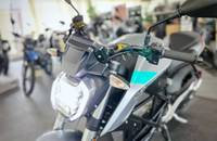 Frontansicht eines silbernen E-Motorrads in einem Showroom.