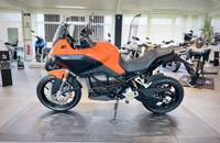 Ein orangefarbenes E-Motorrad wird in einem hellen Showroom aufgestellt.