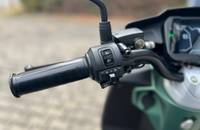 Detailansicht der Bedienelemente und des Lenkers eines Piaggio Scooters.