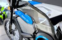 Seitenansicht des elektrischen Motorrads mit blau-grauer Verkleidung und Vorderrad.