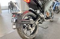 Schwarzes Motorrad im Dreiviertelprofil, sichtbar ist das Hinterrad und die Heckpartie.