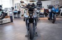 Eine graue E-Motorrad steht in einem Showroom mit weiteren Motorrädern im Hintergrund.