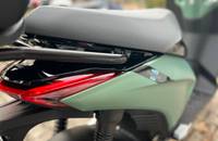 Heckansicht eines Piaggio-Rollers mit grünem Verkleidungsteil und grauem Sitz.