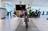 Innenaufnahme mehrerer E-Motorräder in einem modernen Autohaus.