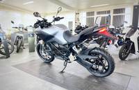 Eine silberne Elektro-Motorrad ist in einem Showroom auf einem Fliesenboden zu sehen.