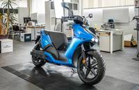 Blaues E-Scooter-Modell (RAY 7.7) in einem modernen Autohaus.