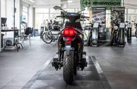 Heckansicht eines schwarzen E-Scooters in einem Autohaus.