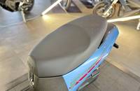 Heckansicht des E-Scooters mit grauem Sitz und blauer Verkleidung.