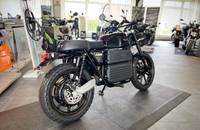 Eine schwarze Elektro-Motorrad, das in einem Showroom auf einem erhöhten Podest steht.