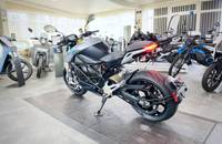 Silbernes E-Motorrad in Dreiviertelansicht in einem Autohaus.