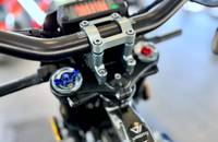 Nahaufnahme des Lenkers und des Tachoanzeiges eines blauen Motorrads.