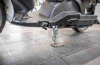 Detailaufnahme der unteren Seitenpartie und der Federung eines elektrischen Scooters.