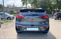 Heckansicht eines grauen KIA Niro Elektroautos vor einem Autohaus.