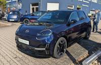 Dunkelblaues Nissan Micra EV vor dem Autohaus Richter & Zech.