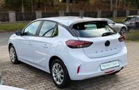 Heckansicht eines weißen Opel Corsa auf einem Autohausparkplatz.