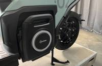 Seitenansicht eines hellgrünen Elektrofahrzeugs mit sichtbarem Rad und Seitenpanel.