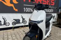 Frontalansicht eines weißen E-Scooters (ZERO) vor einem Autohaus-Banner.