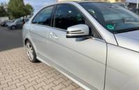 Seitenansicht des silbernen Mercedes-Benz C180 auf einem Parkplatz.