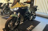 Sagefarbenes E-Motorrad (ZERO) in Dreiviertelansicht in einem Showroom.