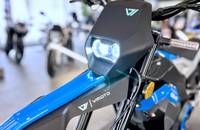 Nahaufnahme der Frontbeleuchtung und des Armaturenbereichs eines blauen E-Scooters.