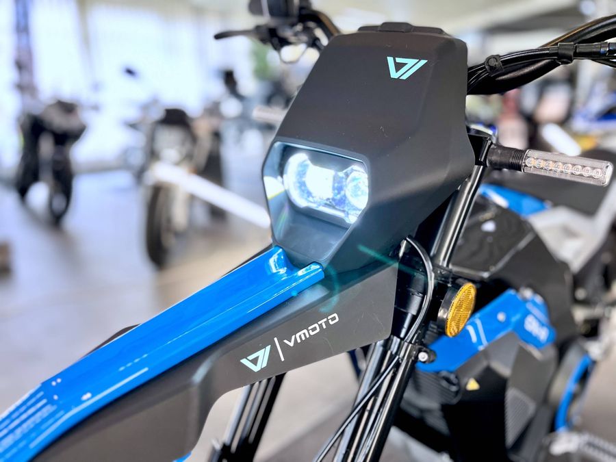 Nahaufnahme der Frontbeleuchtung und des Armaturenbereichs eines blauen E-Scooters.