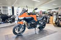 Seitenansicht eines orangefarbenen E-Motorrads (ZERO) in einem Showroom.