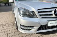 Frontansicht eines silbernen Mercedes-Benz C-Klasse auf einem Pflasterboden.