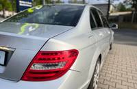 Außenansicht des silbernen Mercedes-Benz Sedans mit sichtbarem Heck und Rücklicht.