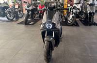 Frontalansicht eines grauen elektrischen Scooters in einem Showroom.