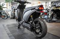 Seitenansicht eines grauen Elektrorollers in einem Autohaus.