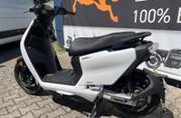 Seitenansicht des weißen E-Scooters ZERO LS1, geparkt vor einem Autohaus-Banner.