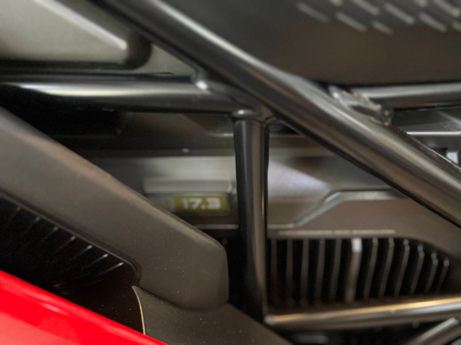 Nahaufnahme der Frontschürze und des Kühlergrills eines roten Elektrofahrzeugs.